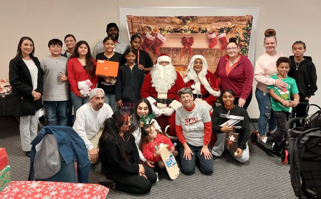 Parole Agent II Specialist (Community Reentry Unit) Jasmine Lopez is on the left with giveaway participants and their families. 