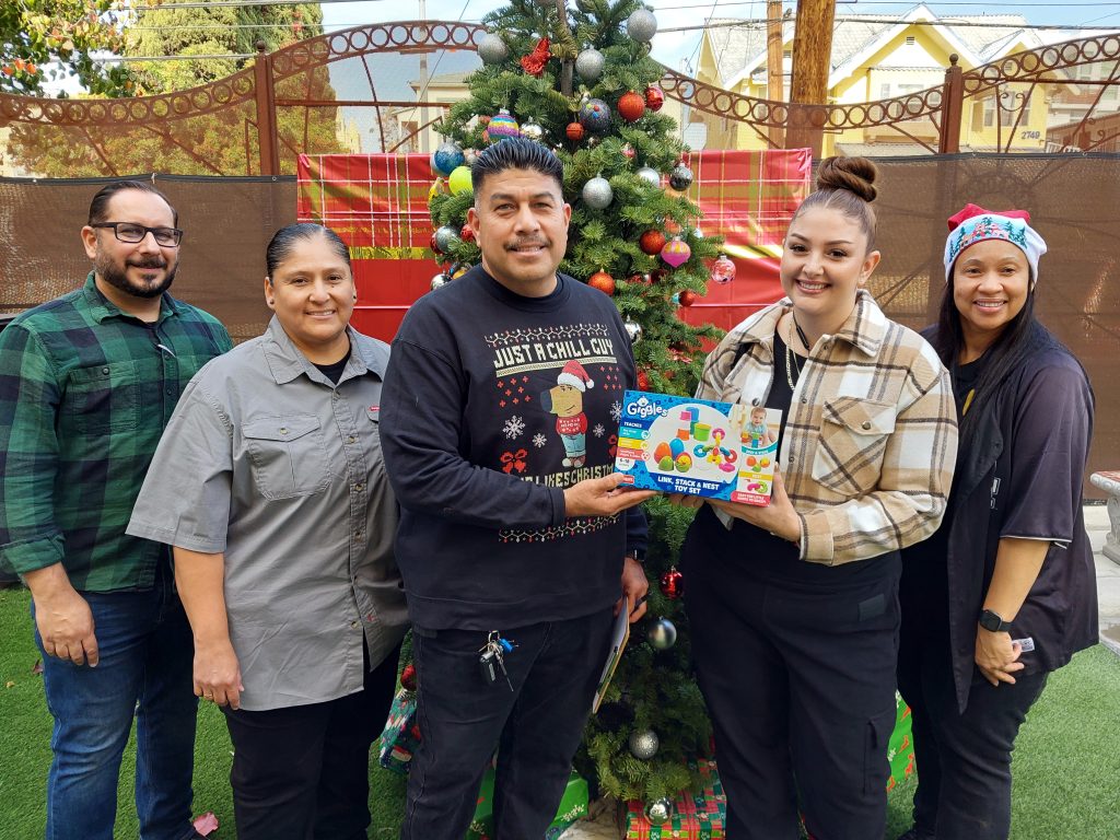 Parole agents and staff with gifts and a holiday Christmas tree in the background.