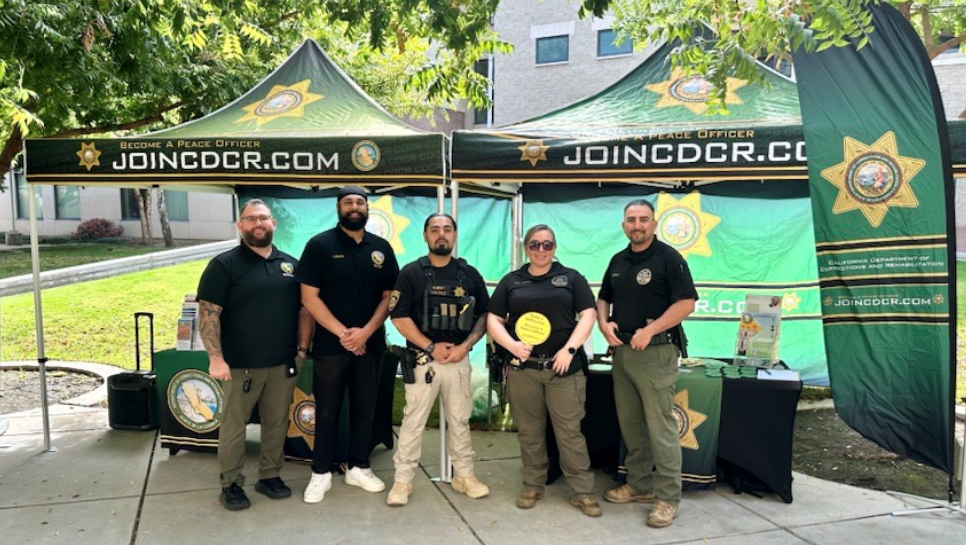 Recruiters at Fresno State, recruitment tables in the background