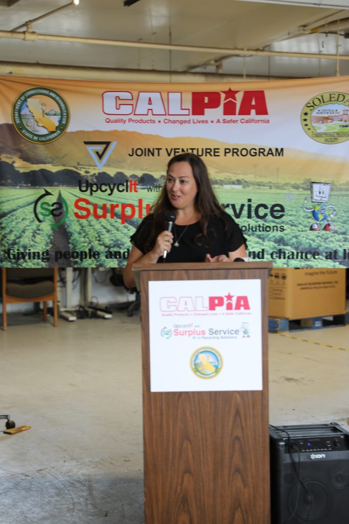 Debi Kamakani speaking at a podium