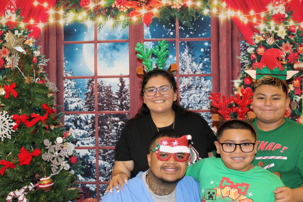 A family at Mule Creek State Prison take a photo during the annual holiday event, Merry Grinchmas. 