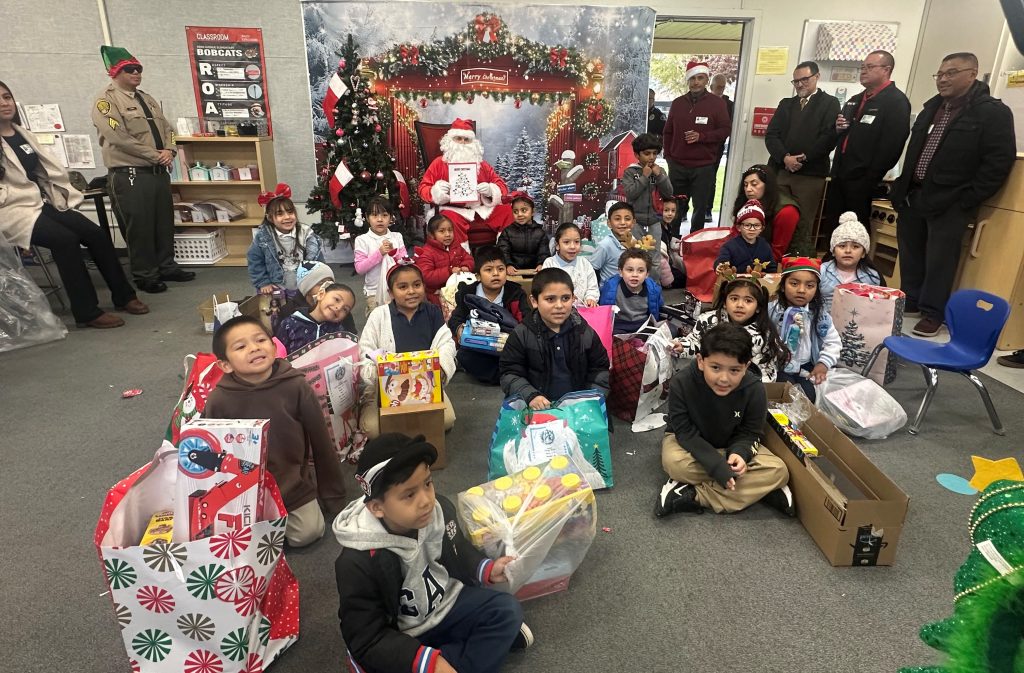 Santa and school children with North Kern State Prison volunteers.