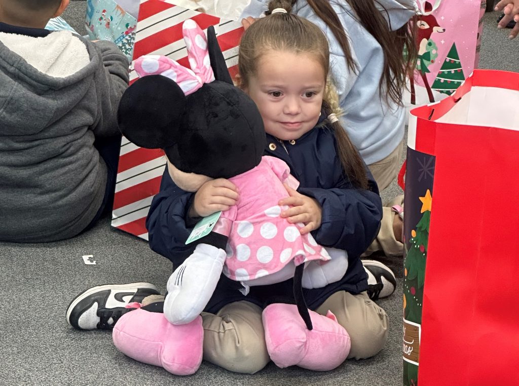 A child with a present thanks to North Kern State Prison volunteers.
