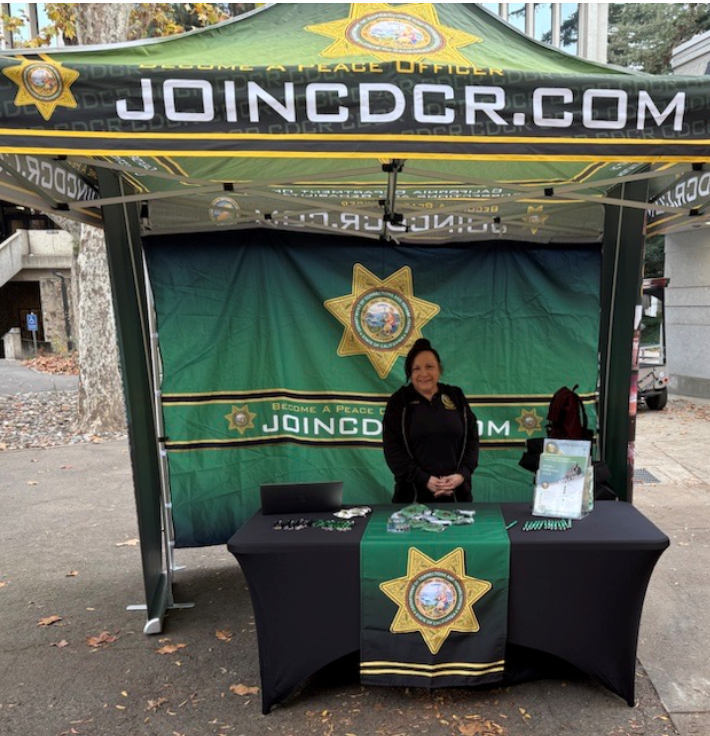 Recruiter at Sac State behind a CDCR table