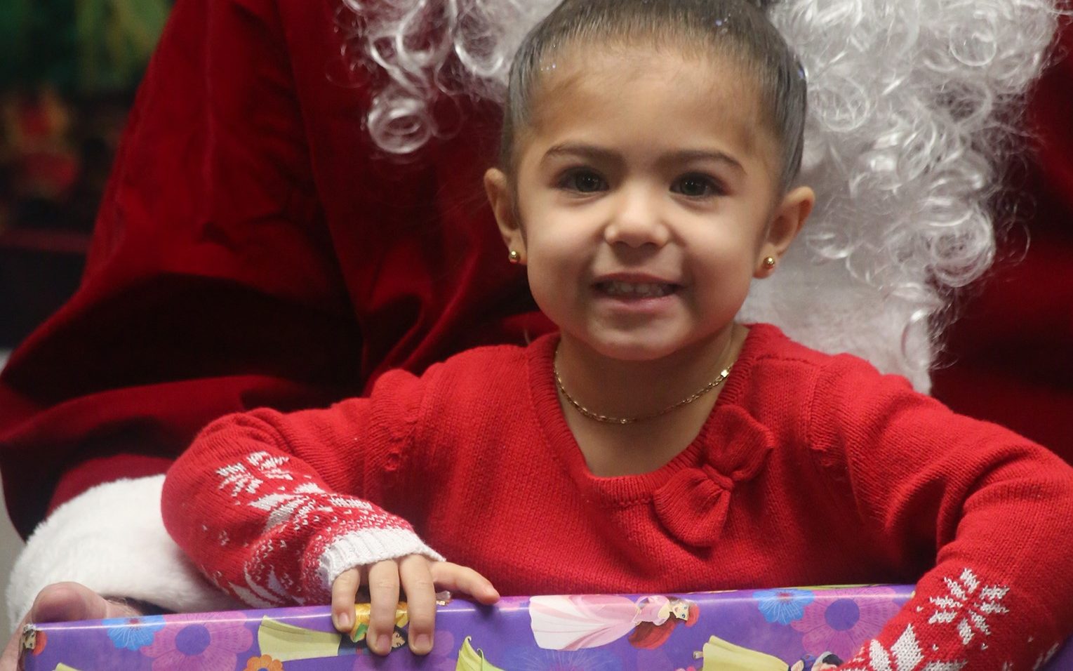 A child receives a gift from Santa thanks to Wasco State Prison-Reception Center.