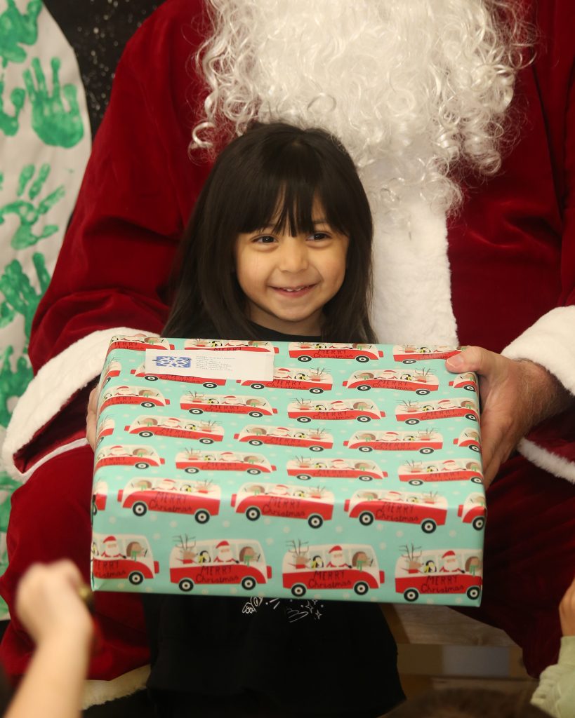 A smiling child with a gift donated by WSP-RC.