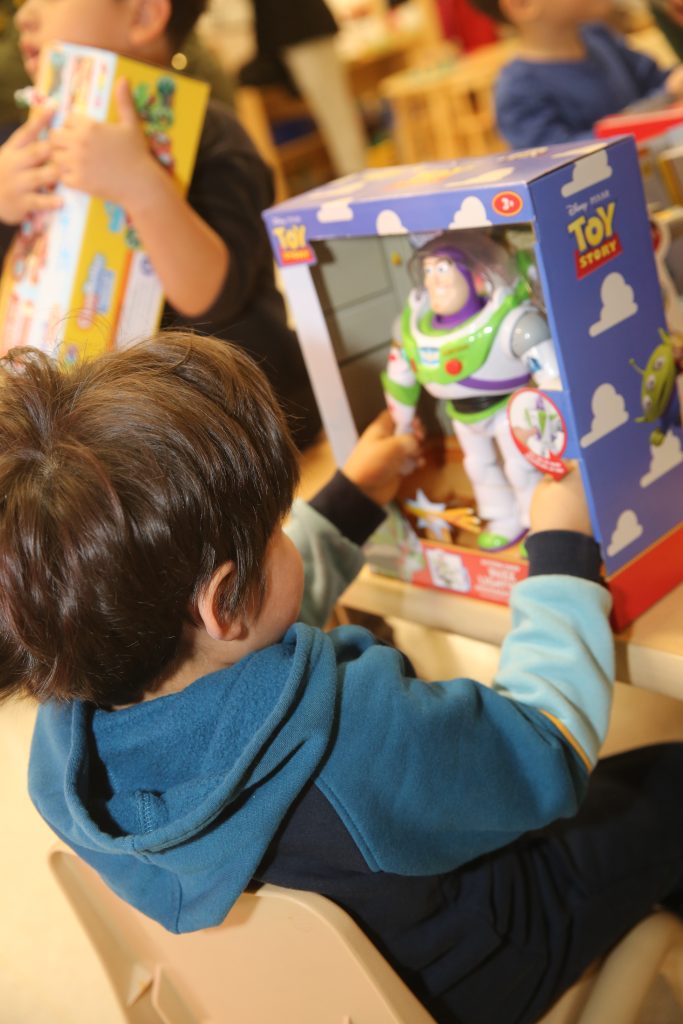 A child opens a present thanks to WSP-RC Adopt-a-Child program for 2025.