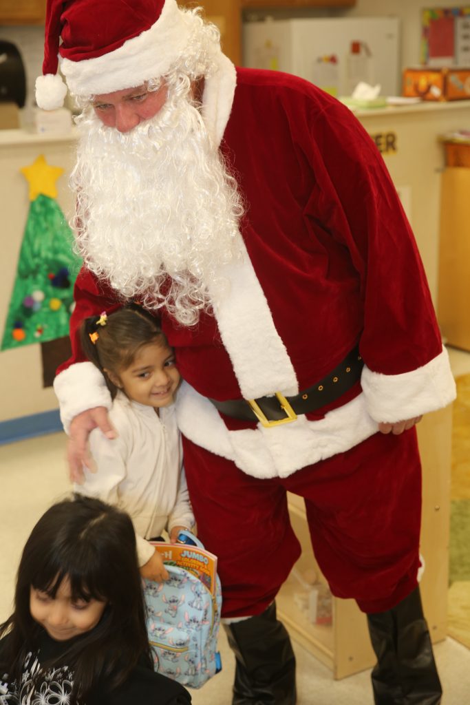 WSP-RC volunteer Santa hugs a child. 