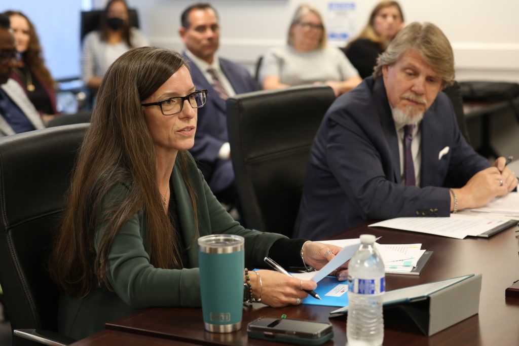 Acting Director Suzie Changus speaking at a board meeting alongside Bill Davidson, retiring general manager.