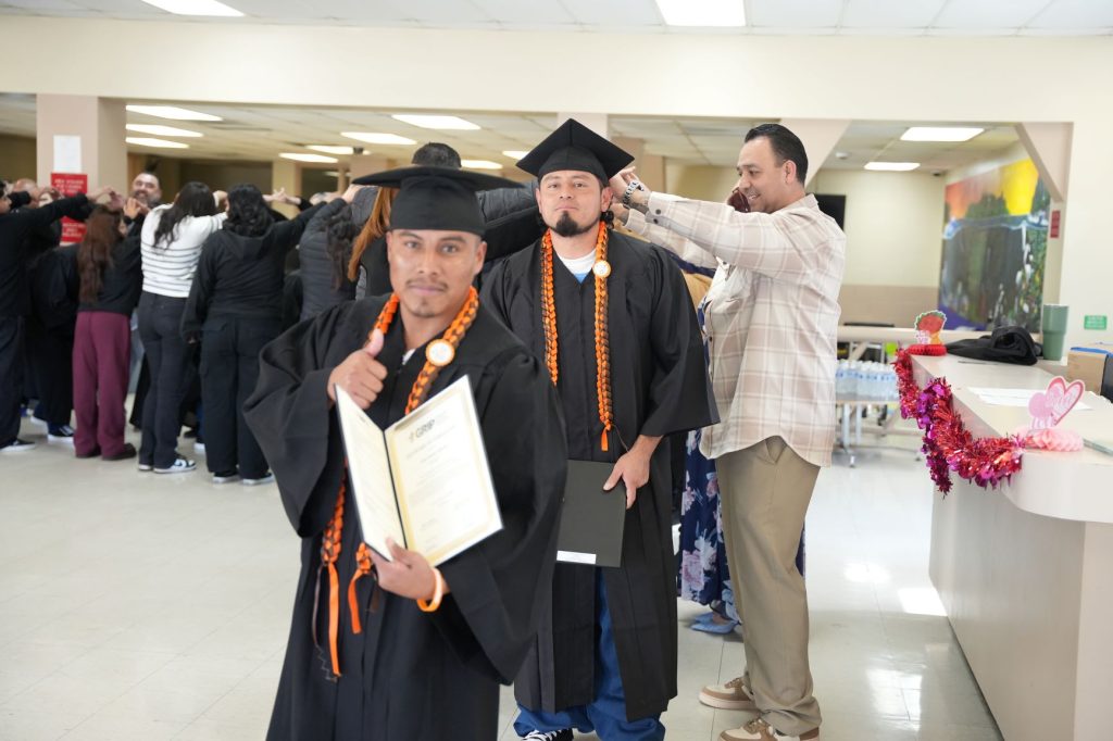 grad giving thumbs up with certificate