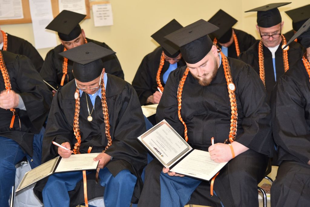 Graduates signing their certificates