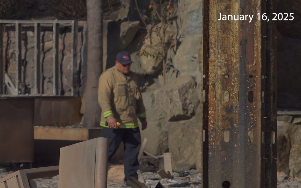 CDCR firefighter walks among ruins after the devastating 2025 Los Angeles (LA) fires.