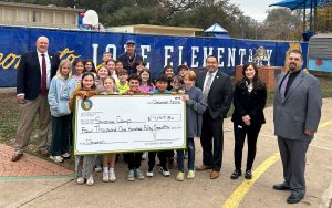 Staff from Mule Creek State Prison donates funds to charities, including a science came at Ione Elementary School.