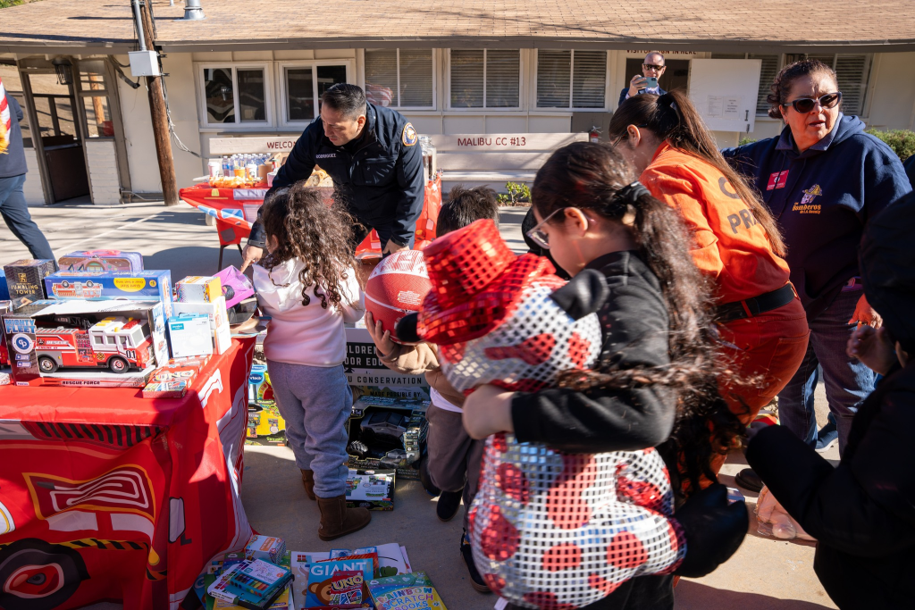 camp participants passing out toys to children