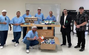 The incarcerated population shown with staff at Pleasant Valley State Prison, or PVSP, in Coalinga and boxes of donated hygiene items.