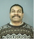 Ernest Rosburough, retired correctional lieutenant wearing a sweater and smiling at the camera.