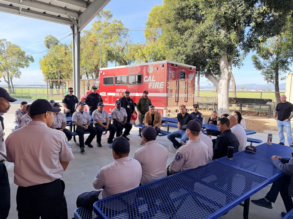 Prince Harry speaking with firefighters in training