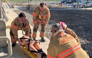 Staff firefighters train at Wasco State Prison-Reception Center (WSP-RC), lifting a dummy on a stretcher.