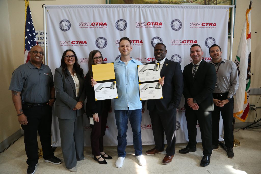 An incarcerated individual receives his job certification at a CALCTRA graduation at Folsom State Prison.
