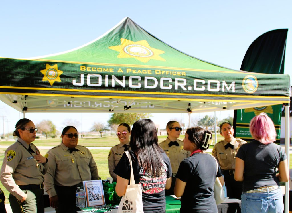 Staff in an outdoor booth, greeting students