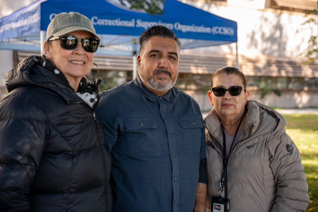 Three people at the remembrance memorial at CIM.