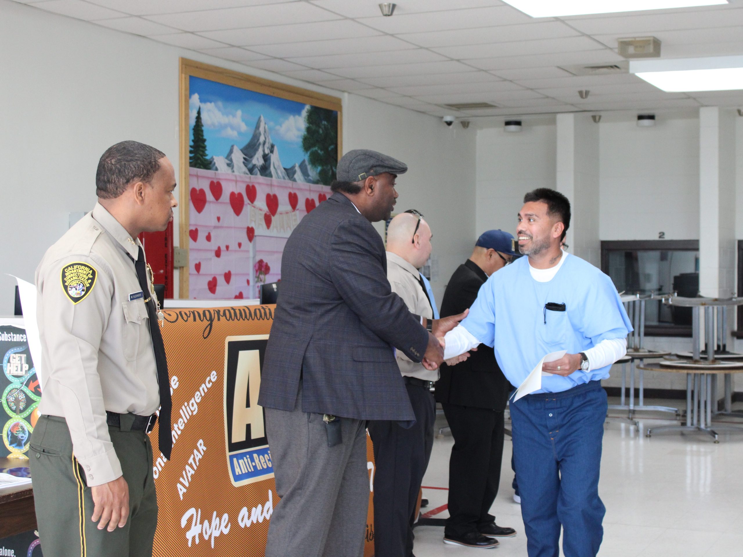 Incarcerated ARC graduate from Centinela State Prison (CEN) shakes hands with acting associate warden Andre Green during the graduation ceremony