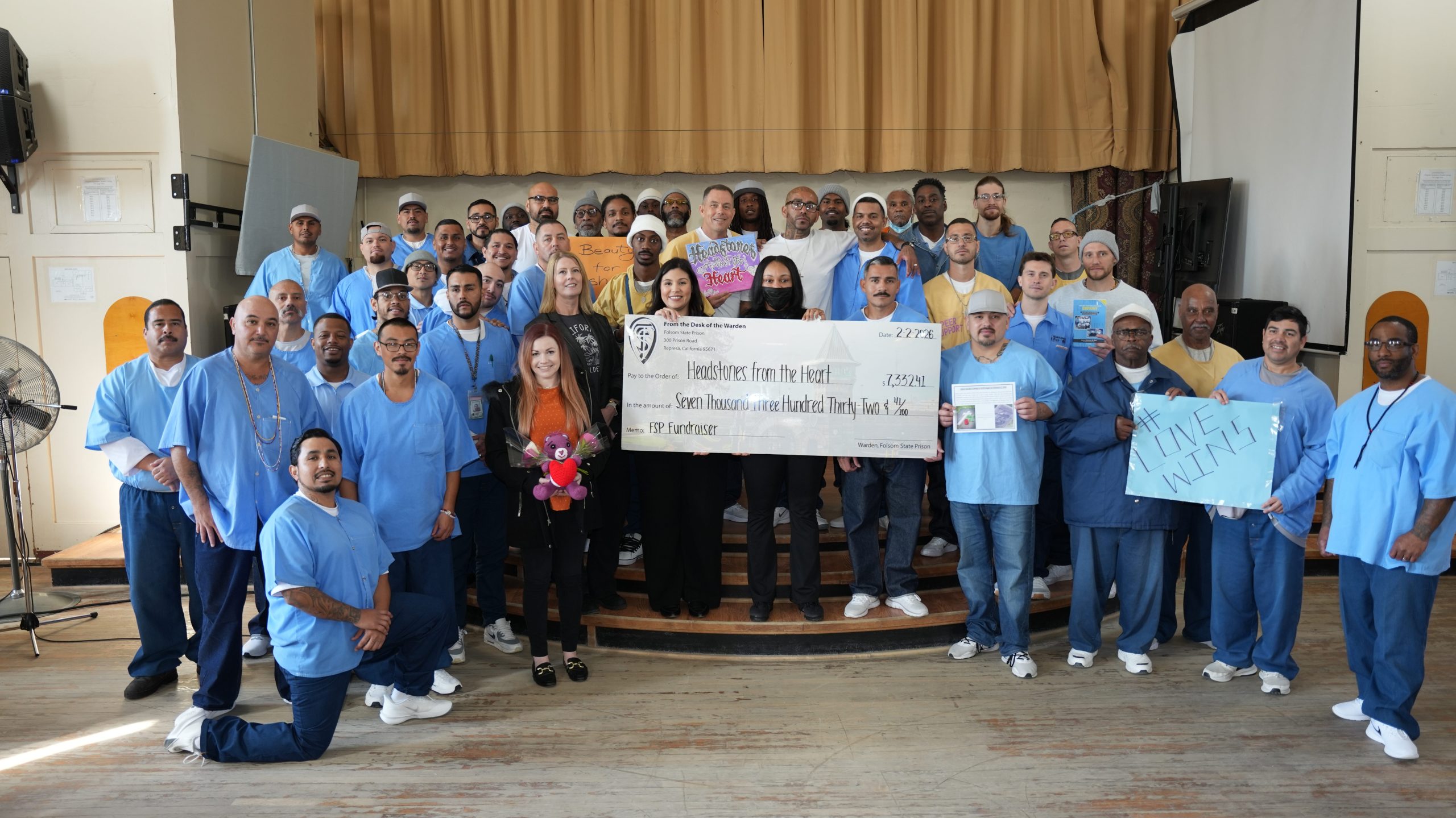 FSP incarcerated with staff, holding donation check