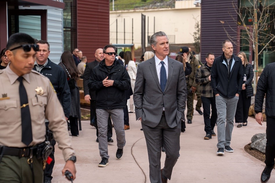 Governor Newsom walking with a group of people at the San Quentin Learning Center ribbon cutting event