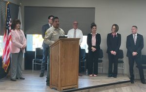 High Desert State Prison promotional ceremony with executives and someone speaking at a lectern.