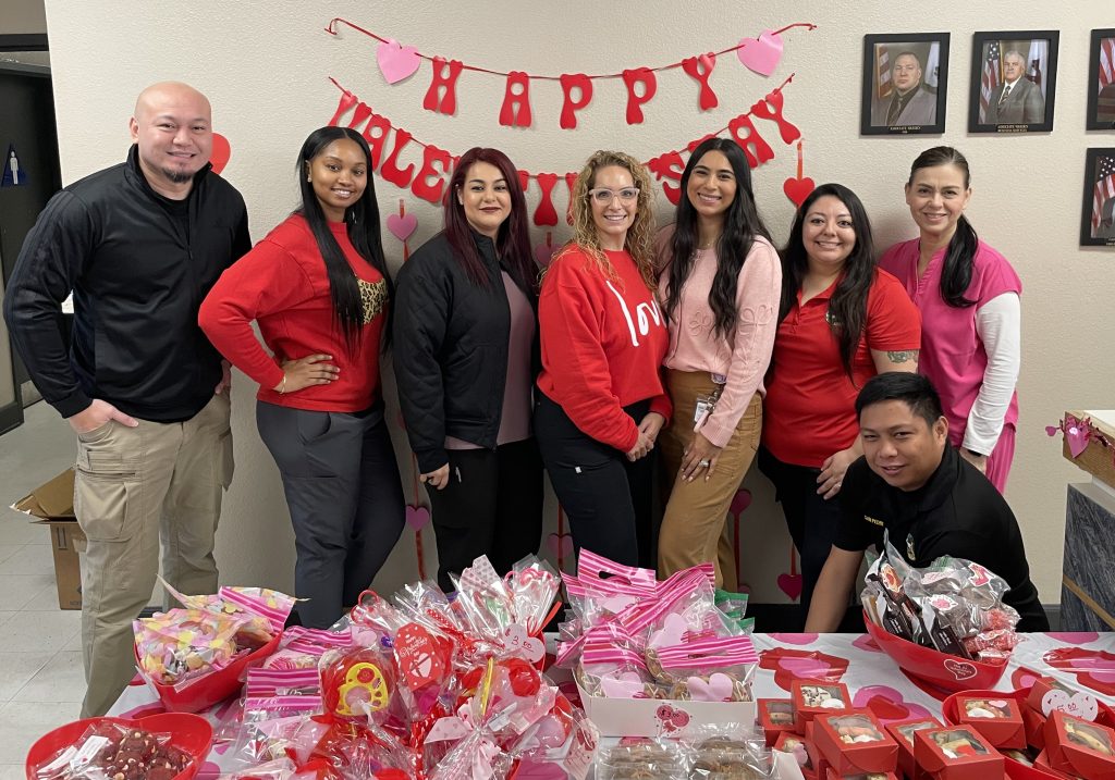WSP staff stand behind table of baked treats for their ISUDT bake sale
