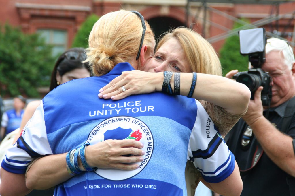 A grieving person hugs one of the Police Unity Tour riders in Washington, D.C.