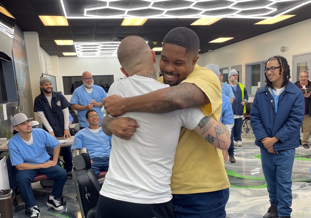 A peer support mentor hugs Vic Blends at Valley State Prison, Chowchilla, California, February 2026.