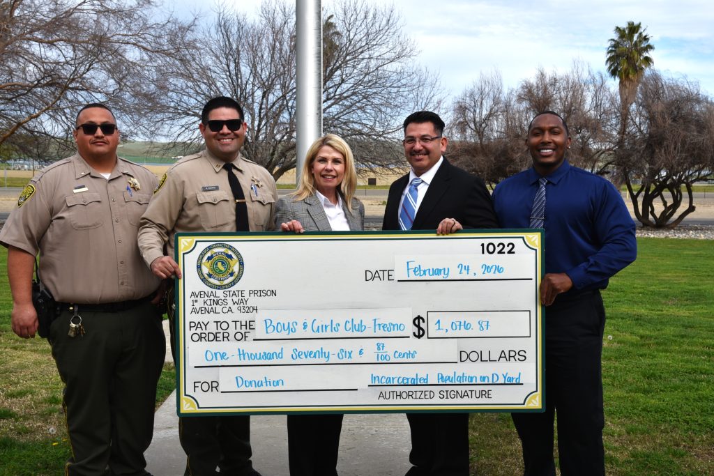 Five ASP staff stand holding an oversized check for $1076.87 for Boys and Girls Club Fresno.