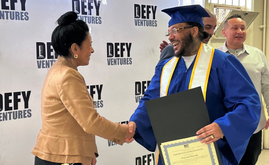 CTF warden shakes hands with happy graduate
