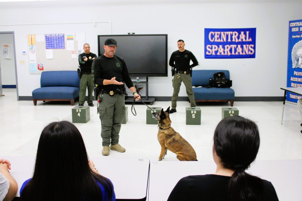 Three Centinela investigative services unit officers and a K9 speak to high school law academy students.