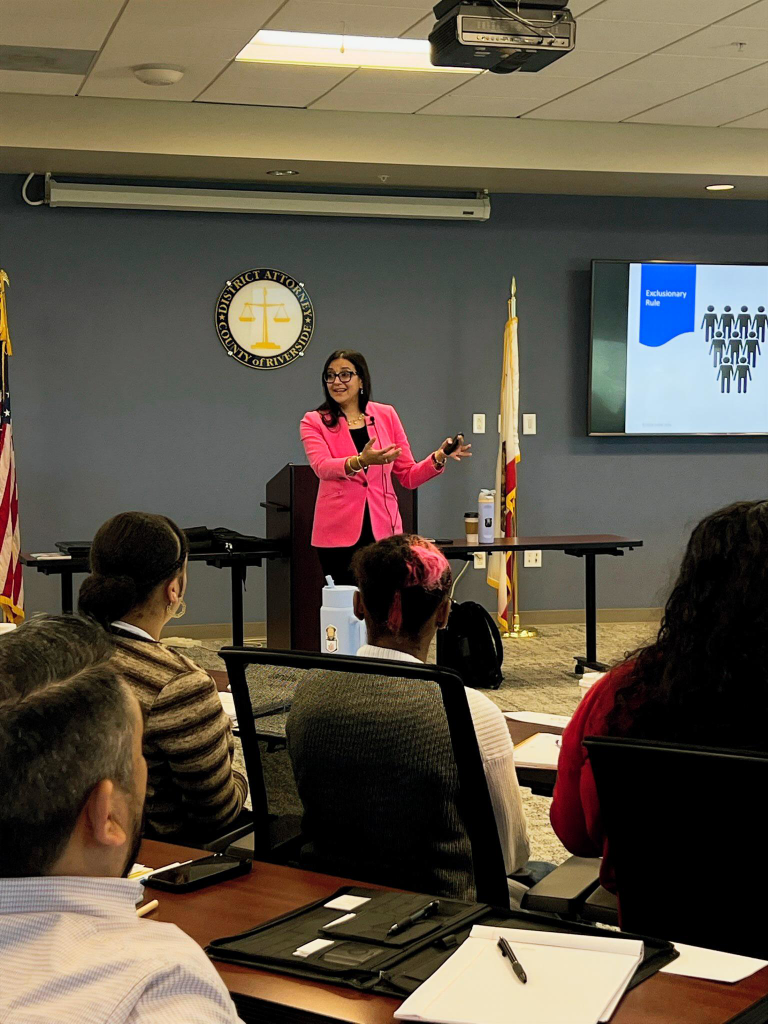 Woman speaks in front of group of seated people for California Crime Victims Assistance Association Riverside DA Office Presentation