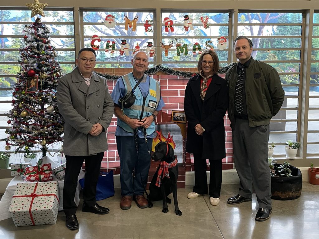 3 staff members and incarcerated person stand with service dog