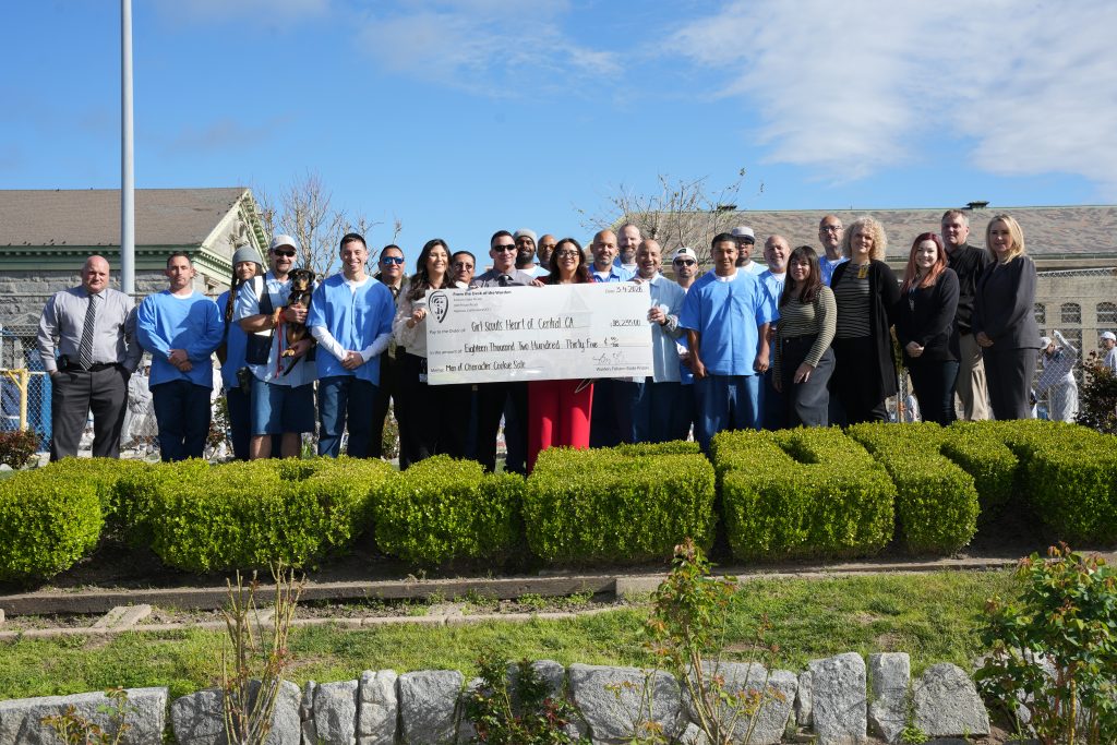 FSP Incarcerated and staff pose with large check for Girl Scouts Heart of Central CA