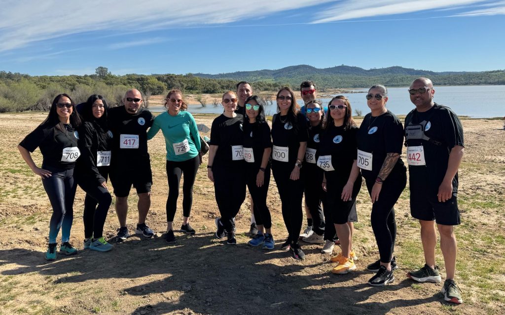 DAPO staff and family stand together in front of lake