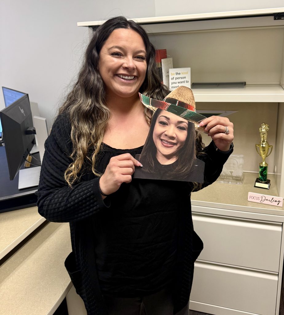 Jane Moses holds up printed cut out photo of her mentor