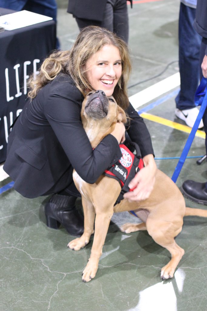 Staff member hugging dog