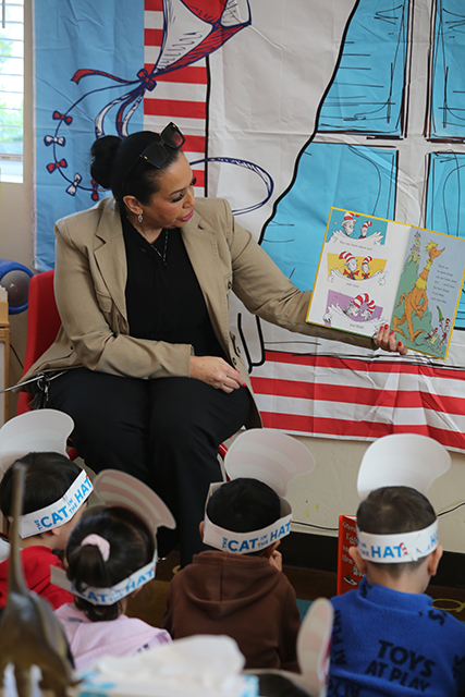 CDCR staff member reading book to group of children