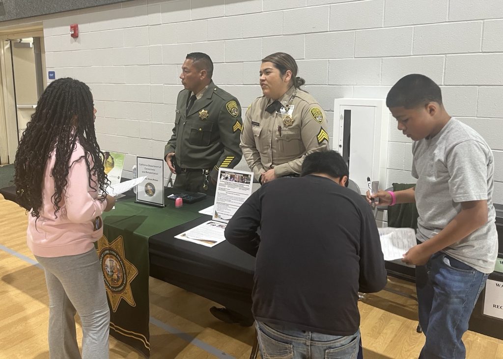 Recruiters interact with students at a career fair.
