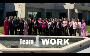 CARU group photo during staff training with the words "team work" overlaying the image.