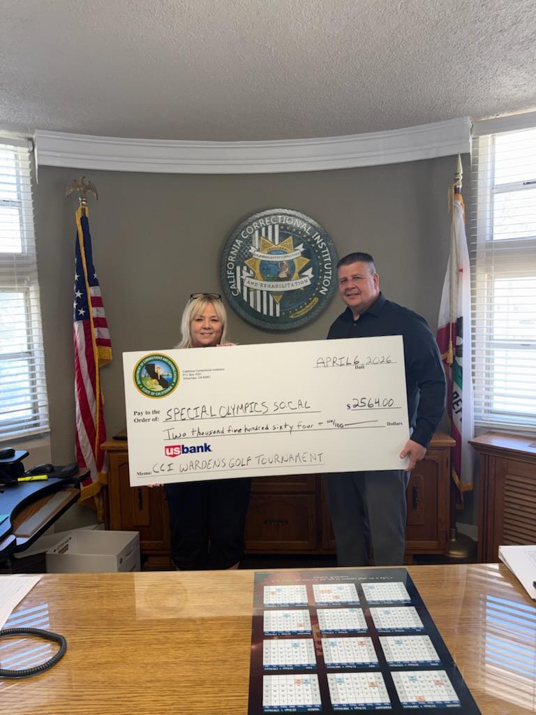 Two CCI staff members hold up large check for $2564.00 made out to Special Olympics SOCAL