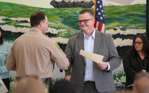 Chief Deputy Warden shakes hands with a recently promoted staff member at CCI.