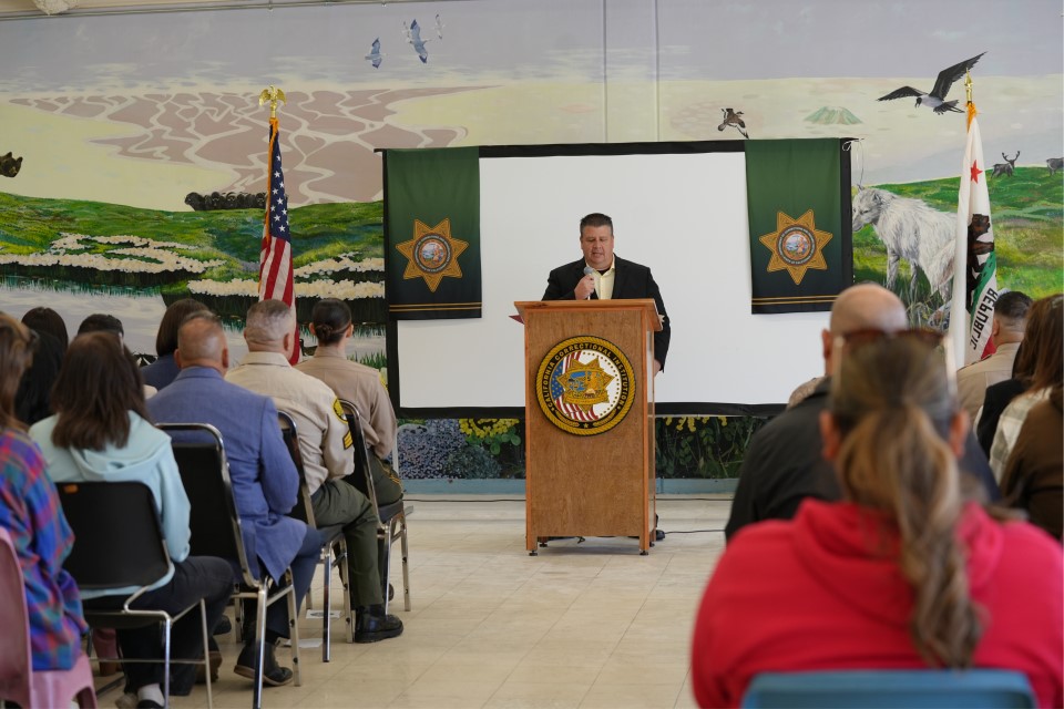 Acting Warden Valdez speaks from a lectern. 