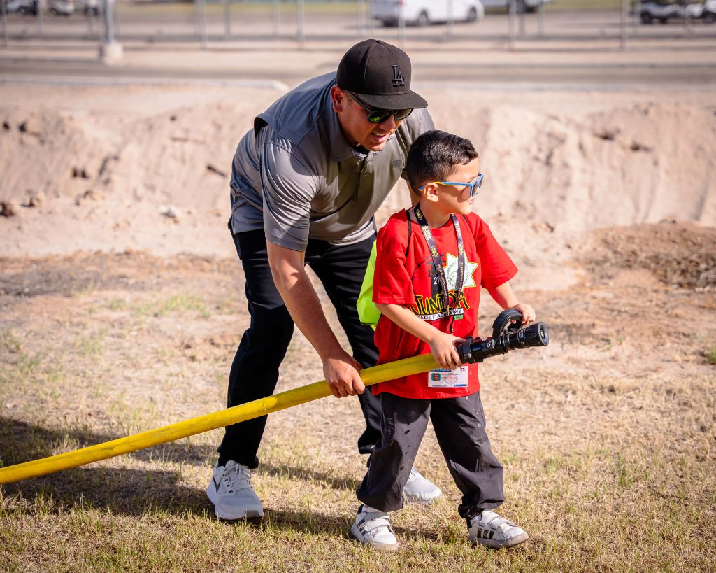 A child holds a fire hose as part of the Centinela State Prison Junior Cadet Academy held over spring break, 2026.
