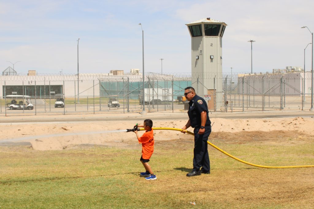 Demonstrating the fire hose for a young child.