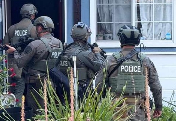 Agents and police check out a house during compliance sweeps.